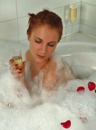 Woman with champagne glass in a bubble bath