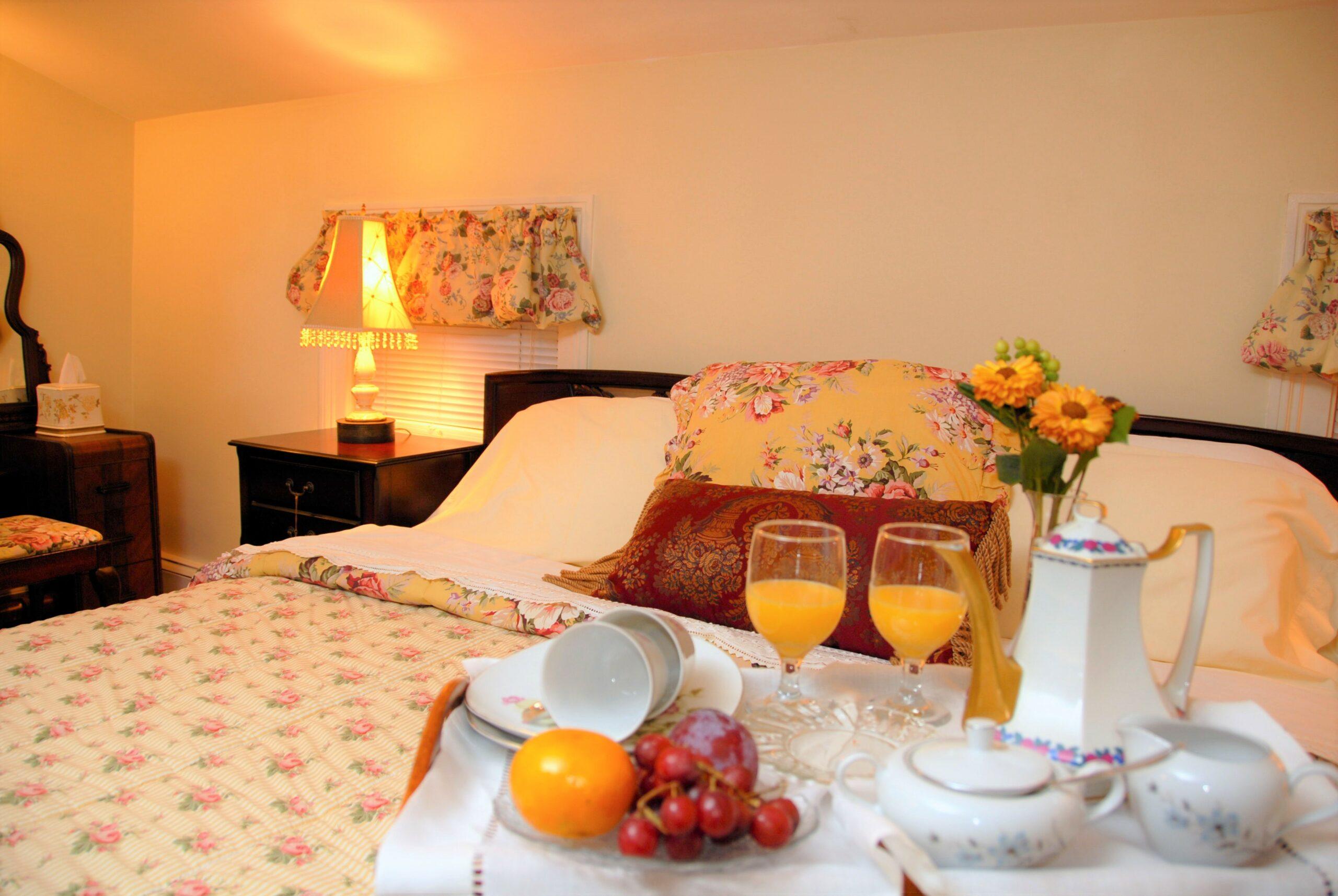 The Champagne Suite with Sleigh king size bed with a tray of orange Juice and fruit